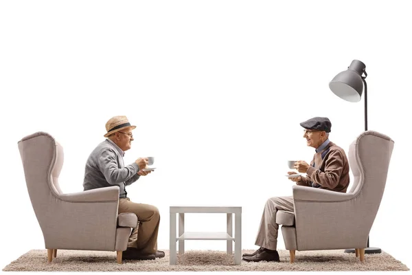 U starších mužů s cups sedí v křeslech — Stock fotografie
