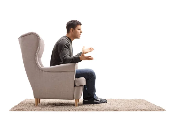 Jeune homme assis dans un fauteuil et se disputant — Photo