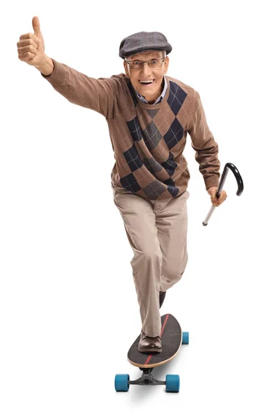 Senior riding a longboard and making a thumb up gesture — Stock Photo, Image
