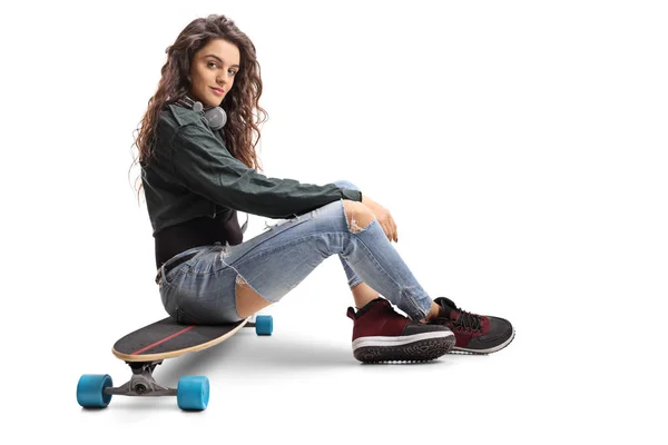 Teenage girl sitting on a longboard — Stock Photo, Image