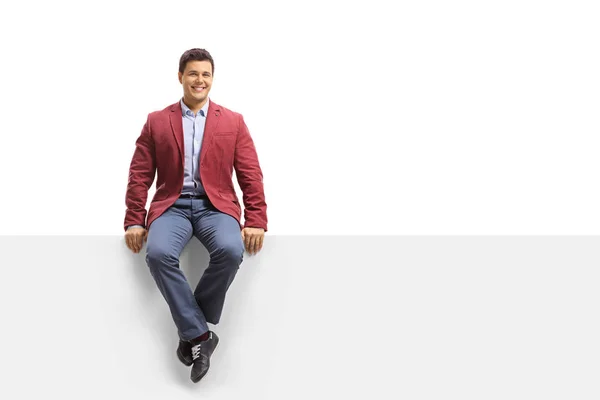 Elegante man zitten op een paneel en glimlachen — Stockfoto