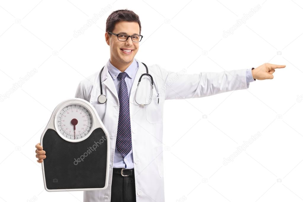 Doctor holding a weight scale and pointing