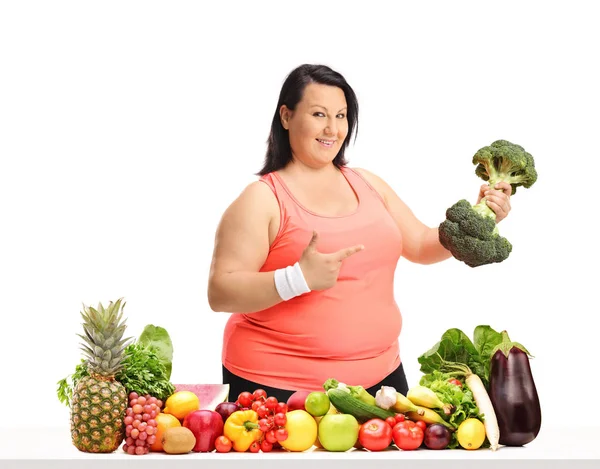 Kobieta Nadwagą Hantle Brokuły Wskazując Stołem Owoców Warzyw Białym Tle — Zdjęcie stockowe