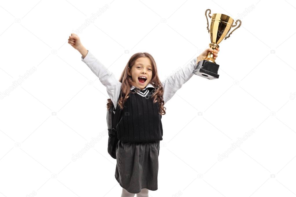 Overjoyed schoolgirl holding a golden trophy isolated on white background