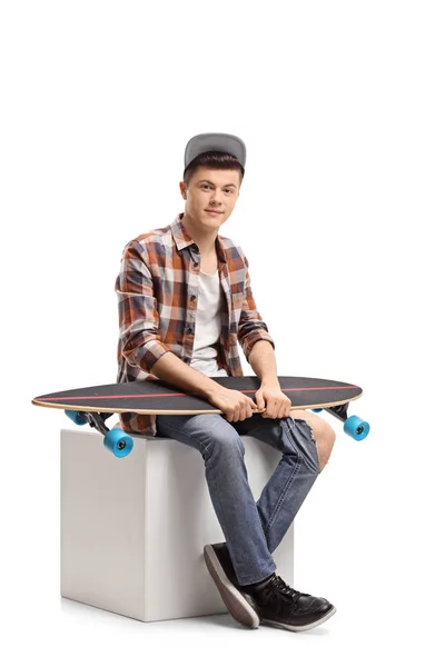 Adolescente Hipster Com Longboard Sentado Cubo Isolado Fundo Branco — Fotografia de Stock