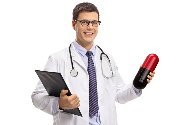 クリップボード および白い背景に分離された大きな錠剤を保持している医師 — ストック写真