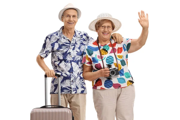 白い背景で隔離スーツケースと手を振っている高齢の女性観光客の高齢者男性の観光 — ストック写真