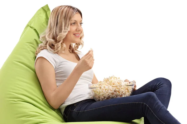 Młoda Kobieta Siedzi Zielony Beanbag Jedzenie Popcorn Białym Tle — Zdjęcie stockowe