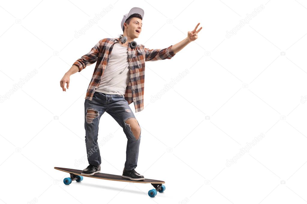 Full length portrait of a teenage hipster riding a longboard and making a peace sign isolated on white background