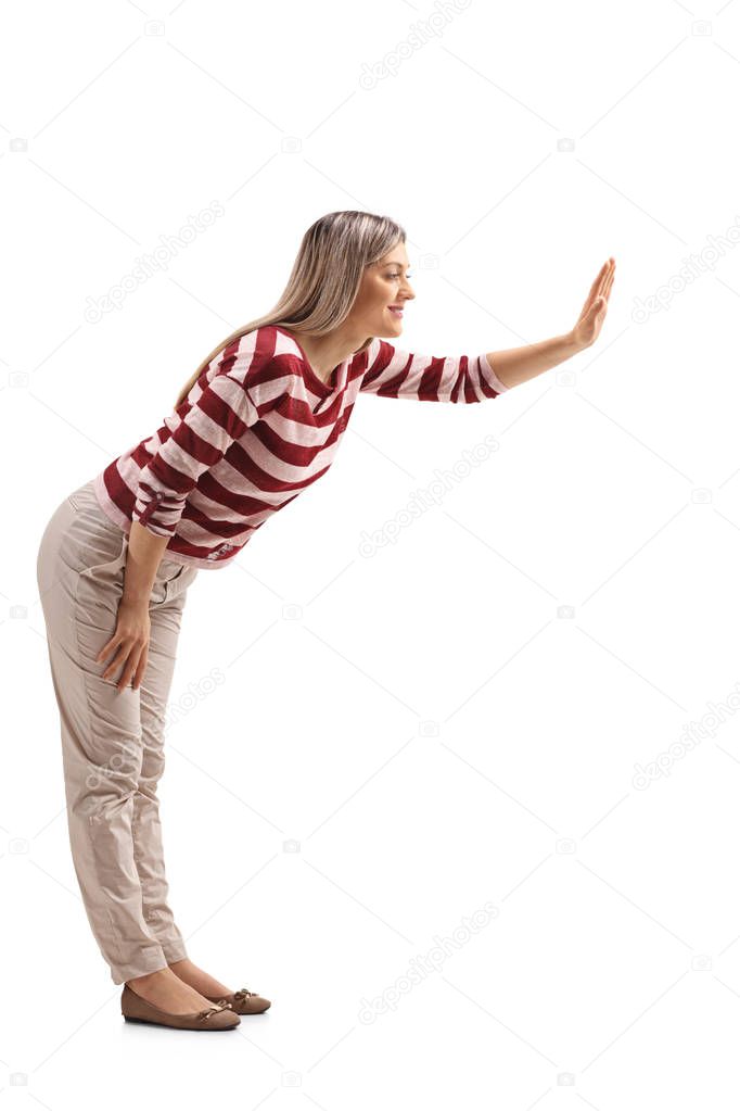 Full length profile shot of a young woman making a high-five gesture isolated on white background