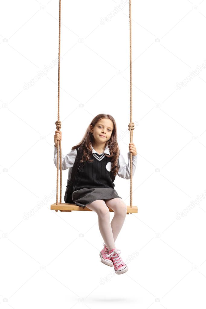 Little schoolgirl sitting on a wooden swing isolated on white background