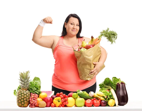 Übergewichtige Frau Mit Papiertüte Die Ihren Bizeps Hinter Einem Tisch — Stockfoto