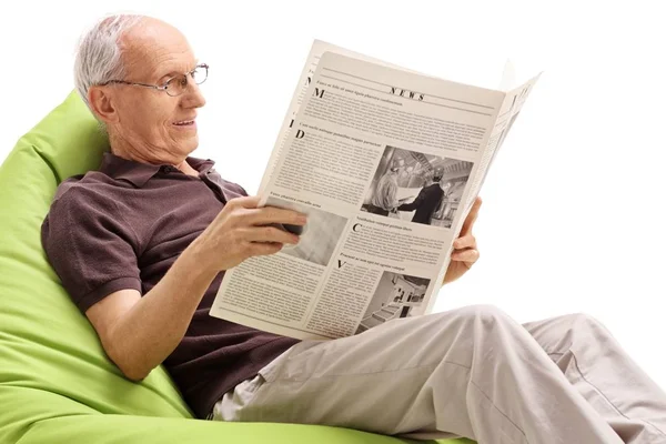 Sénior Sentado Saco Feijão Lendo Jornal Isolado Fundo Branco — Fotografia de Stock