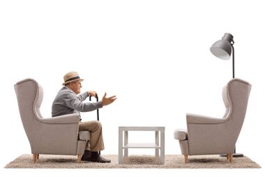 Beyaz arka plan üzerinde izole bir boş koltuk ile konuşan olgun adam