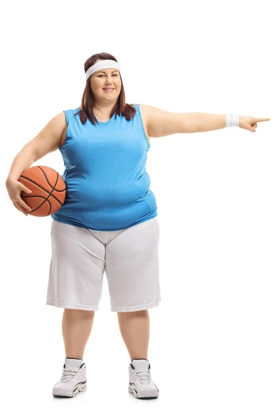 一个超重的妇女在运动衫上的全长肖像举行篮球和指向被隔绝在白色背景上 — 图库照片