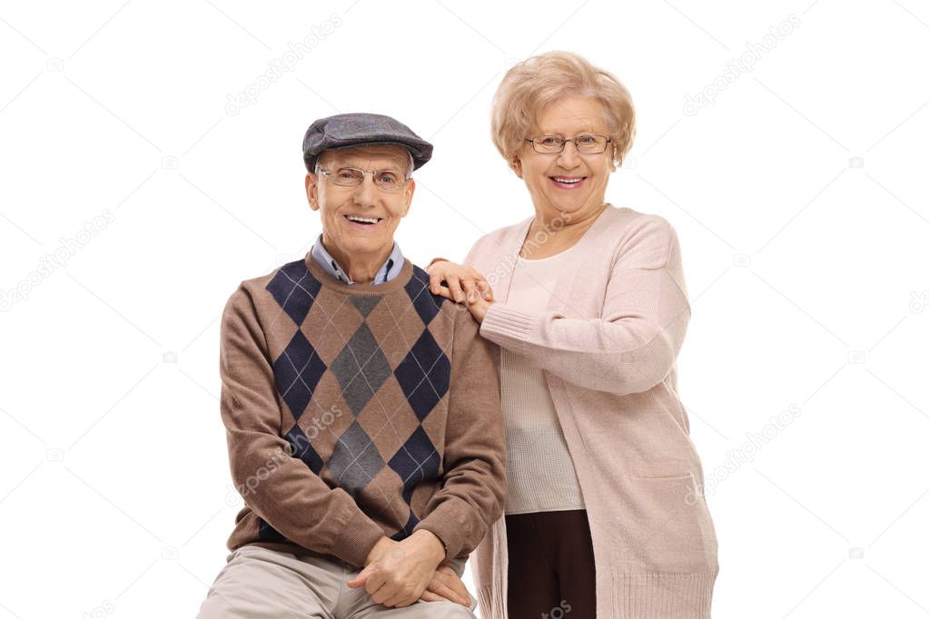 Elderly man and an elderly woman looking at the camera and smiling isolated on white background