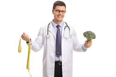 Bir ölçüm bandı ve beyaz arka plan üzerinde izole brokoli tutan doktor