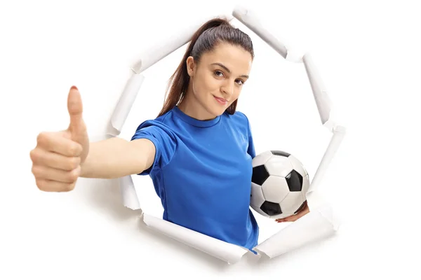 Kobiece Piłkarz Przedzierając Się Przez Papier Dokonywanie Kciuk Górę Znak — Zdjęcie stockowe
