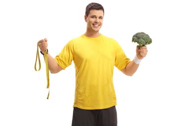 Bir ölçüm bandı ve beyaz arka plan üzerinde izole brokoli ile genç adam