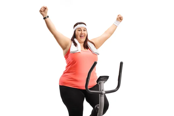 太りすぎの女性運動自転車に 白い背景で隔離の幸福を身振りで示すこと — ストック写真