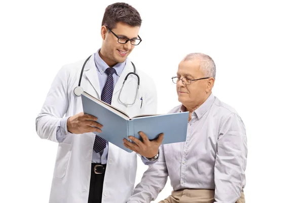 Médecin Montrant Livre Patient Âgé Isolé Sur Fond Blanc — Photo