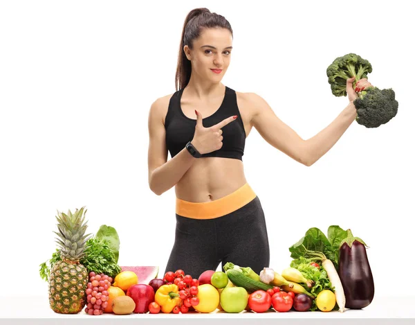 Donna Fitness Che Tiene Manubrio Broccoli Dietro Tavolo Con Frutta — Foto Stock