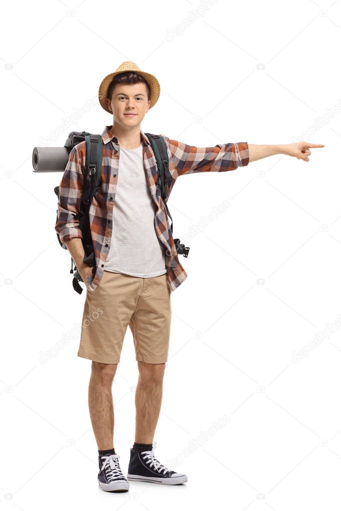 Full length portrait of a teenage tourist pointing isolated on white background