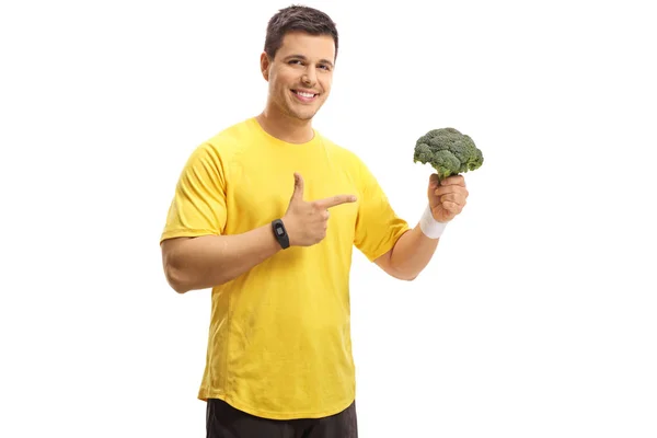 Ung Man Innehav Broccoli Och Pekar Isolerad Vit Bakgrund — Stockfoto
