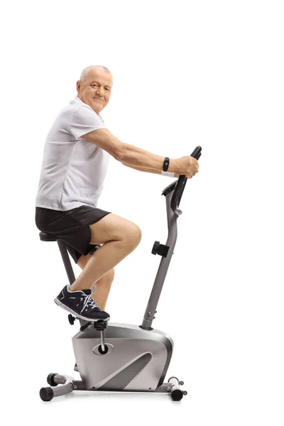 Mature Man Stationary Bike Looking Camera Isolated White Background — Stock Photo, Image