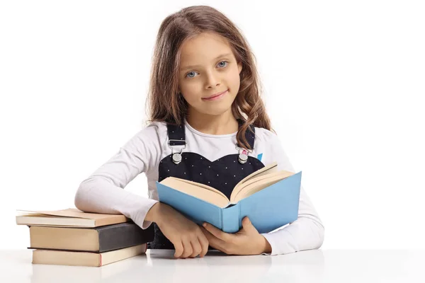 Menina Com Livro Sentado Uma Mesa Olhando Para Câmera Isolada — Fotografia de Stock