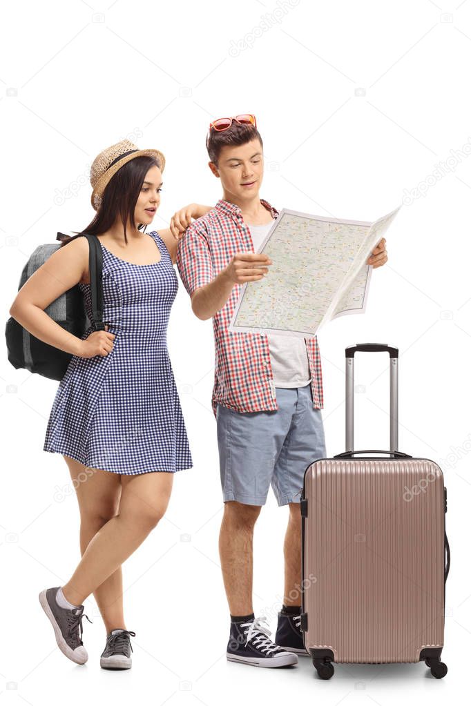 Full length portrait of teenage tourists looking at a map isolated on white background