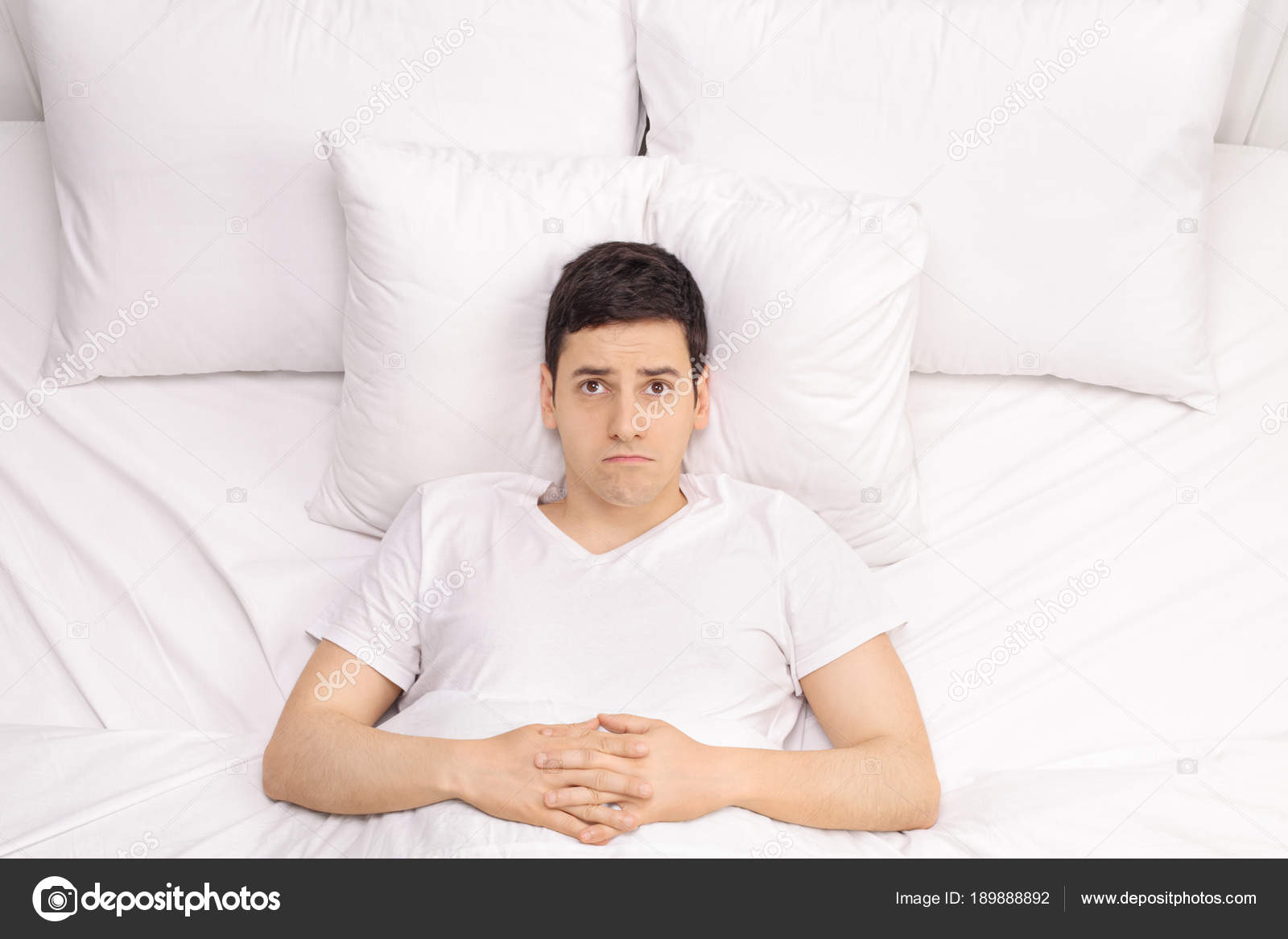 Pensive Young Man Lying Bed Stock Photo by ©ljsphotography 189888892