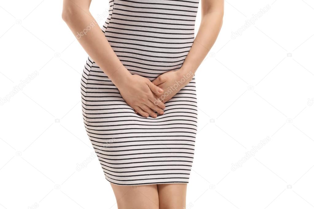 Close-up of a young woman holding her crotch isolated on white background