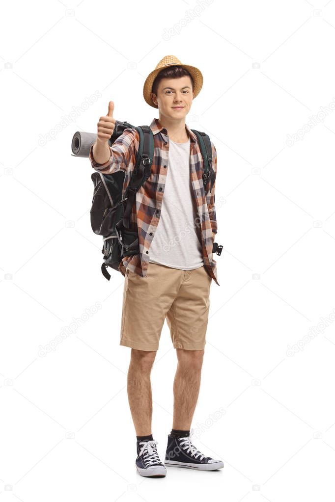 Full length portrait of a teenage tourist making a thumb up gesture isolated on white background