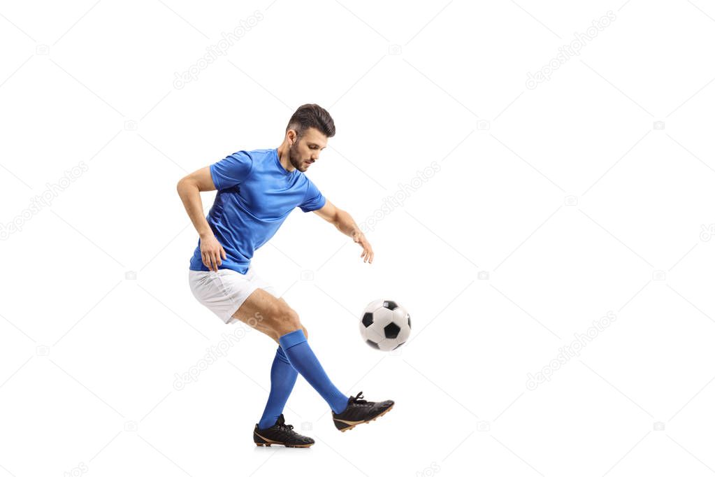 Soccer player juggling a football isolated on white background
