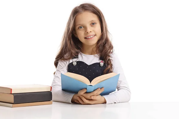 Menina Sentada Uma Mesa Segurando Livro Sorrindo Isolado Fundo Branco — Fotografia de Stock