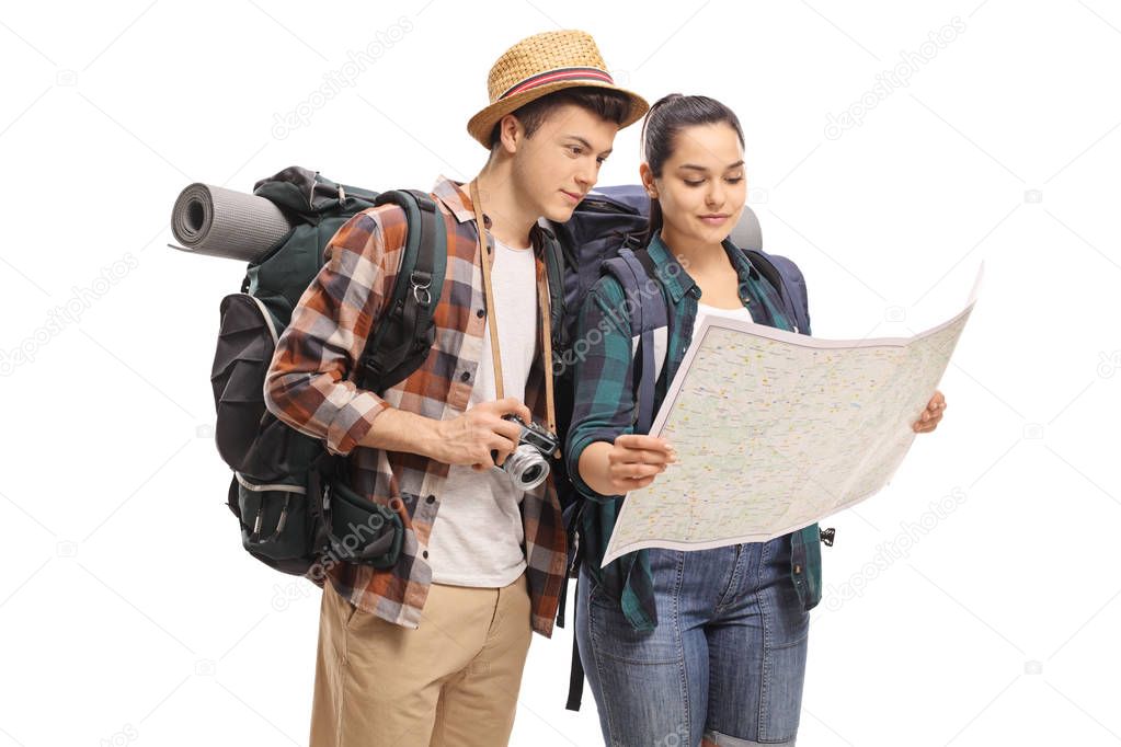 Teenage tourists looking at a map isolated on white background