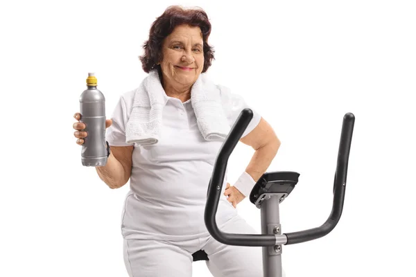 Elderly Woman Stationary Bike Holding Water Bottle Isolated White Background — Stock Photo, Image