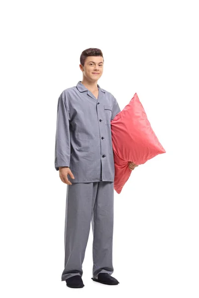 白い背景に分離された抱き枕を抱いてパジャマで 代の少年の完全な長さの肖像画 — ストック写真