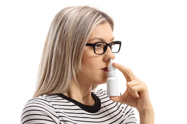 若い女性の白い背景で隔離の鼻スプレーを使用して — ストック写真