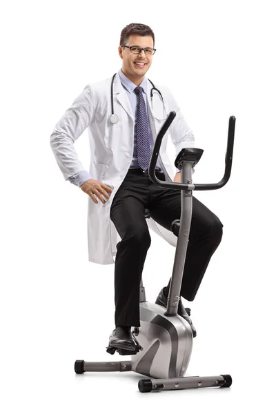 エアロバイク カメラ目線と笑顔で孤立した白い背景に医師 — ストック写真