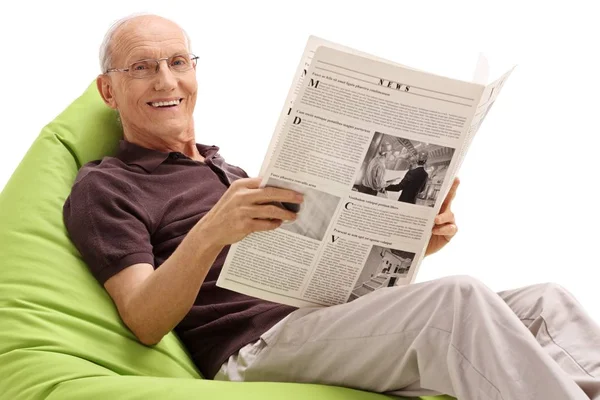 Elderly Man Newspaper Sitting Beanbag Smiling Isolated White Background — Stock Photo, Image