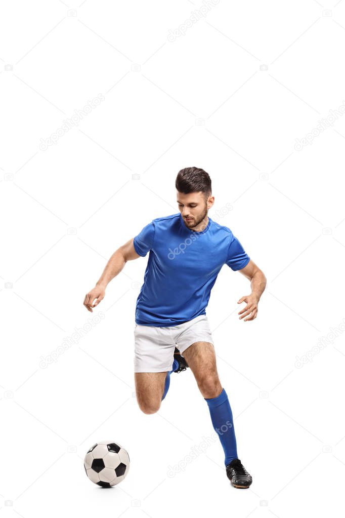 Full length portrait of a soccer player dribbling isolated on white background