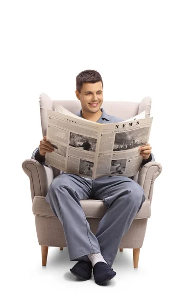 Ung Kille Pyjamas Sitta Fåtölj Och Läsa Tidning Som Isolerad — Stockfoto