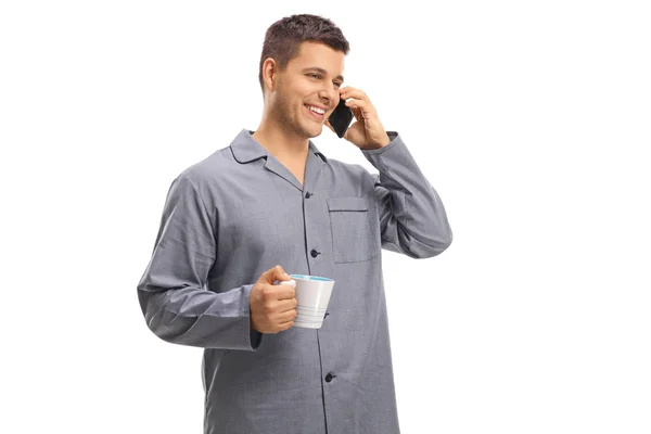 Молодий Чоловік Піжамі Розмовляє Телефону Тримає Чашку Ізольовану Білому Тлі — стокове фото