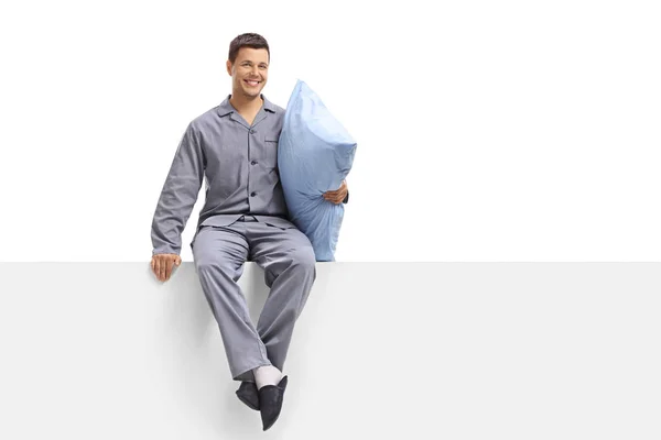 Ung Man Pyjamas Håller Kudde Och Sitter Panel Som Isolerad — Stockfoto