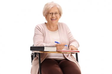 Bir okul sandalyede oturuyor ve izole üzerinde beyaz arka plan gülümseyen Olgun kadın