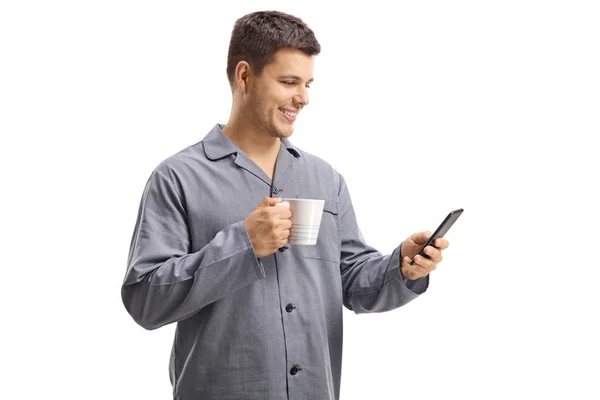 Молодой Человек Пижаме Телефоном Чашкой Изолированы Белом Фоне — стоковое фото
