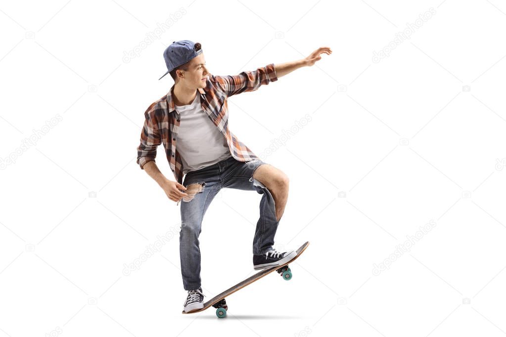 Full length profile shot of a teenage skater doing a manual isolated on white background