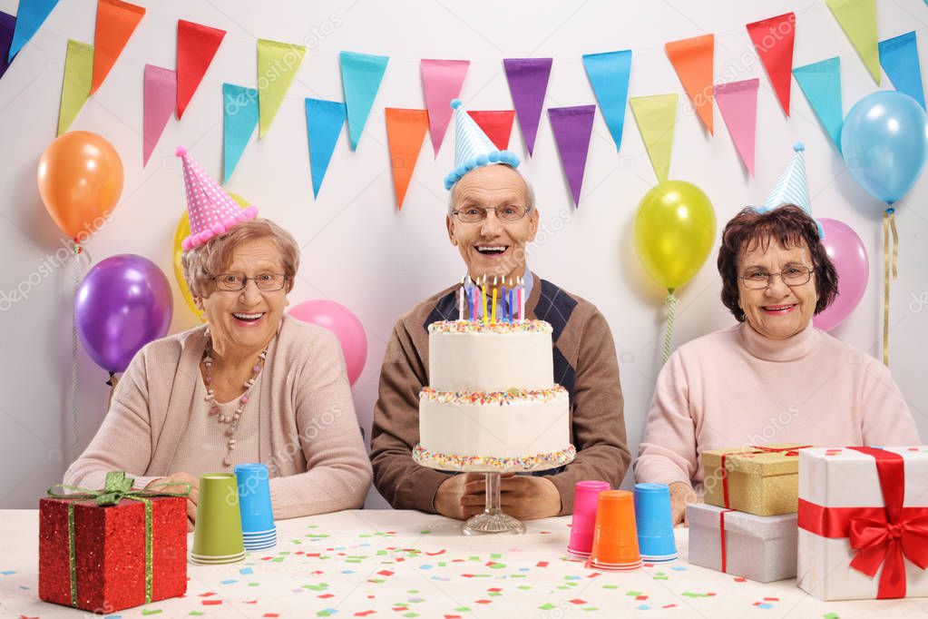 Seniors with party hats and a cake celebrating a birthday